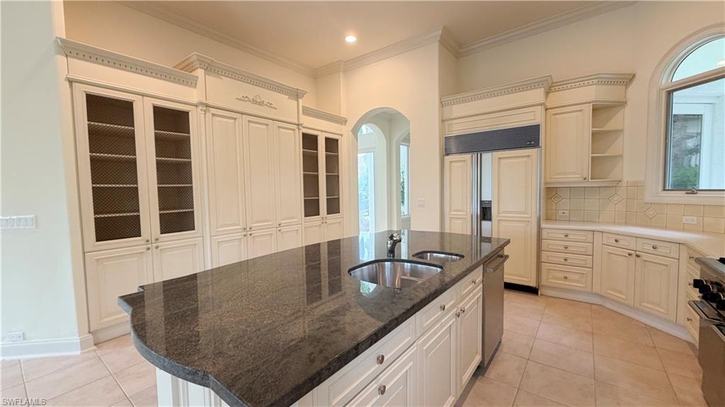 Expansive kitchen island with a dark stone countertop and dual under-mount sinks