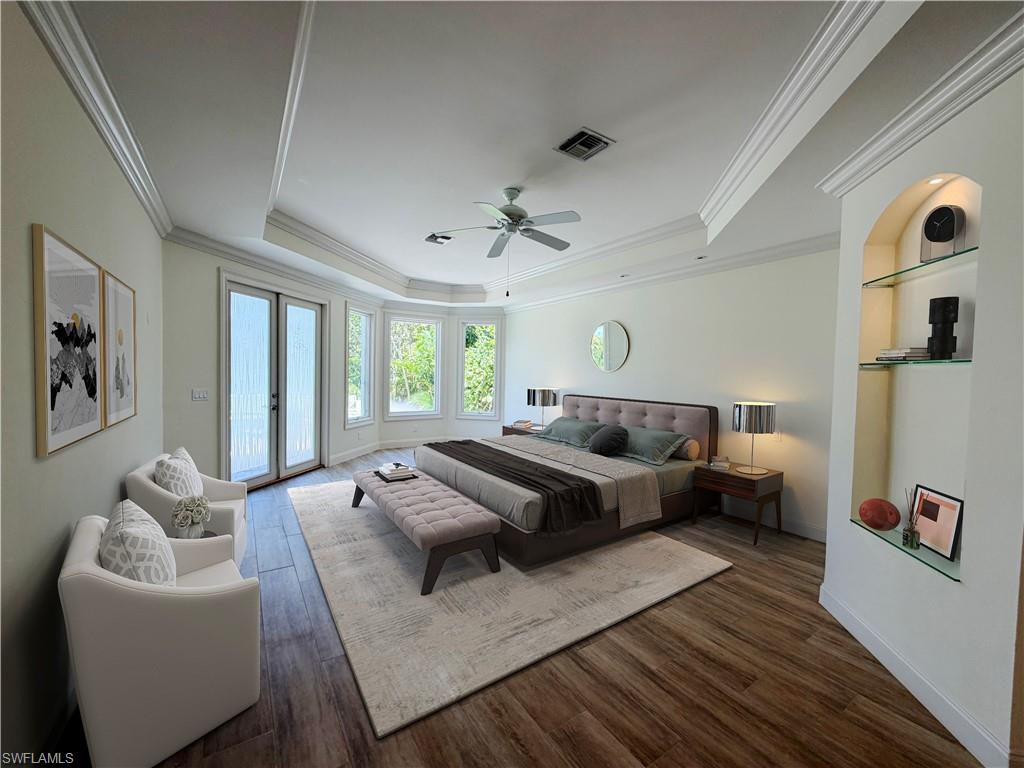 Tray ceiling with crown molding, wood-finish flooring, built-in shelving with glass accents, bay windows, and glass panel patio doors