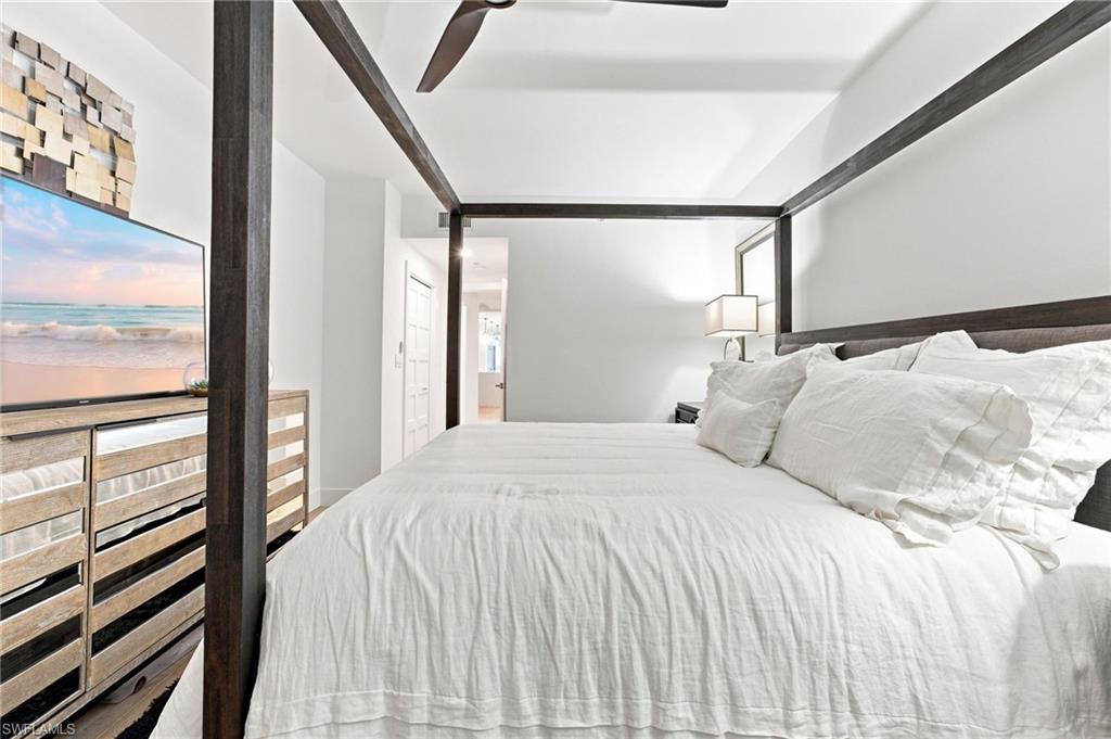 Recessed lighting, ceiling fan, and a wood-finish four-poster bed frame