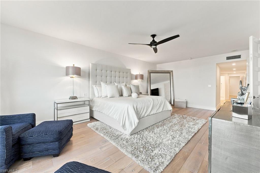 Light wood-finish flooring with recessed ceiling lighting, a ceiling fan, and a wall-mounted ventilation register