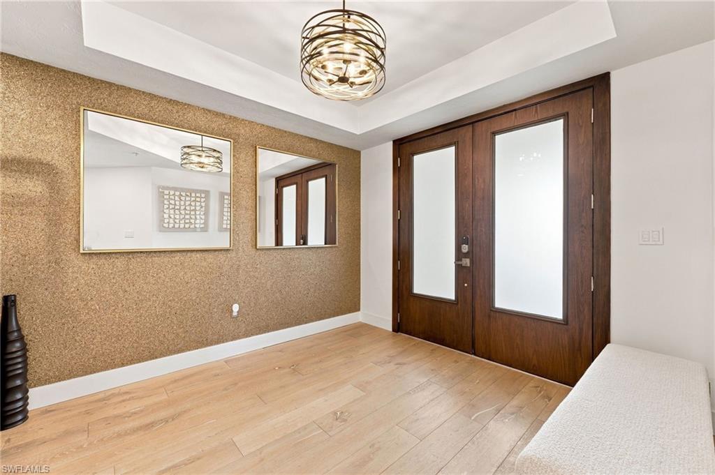 Double entry doors with frosted glass panels and dark wood framing