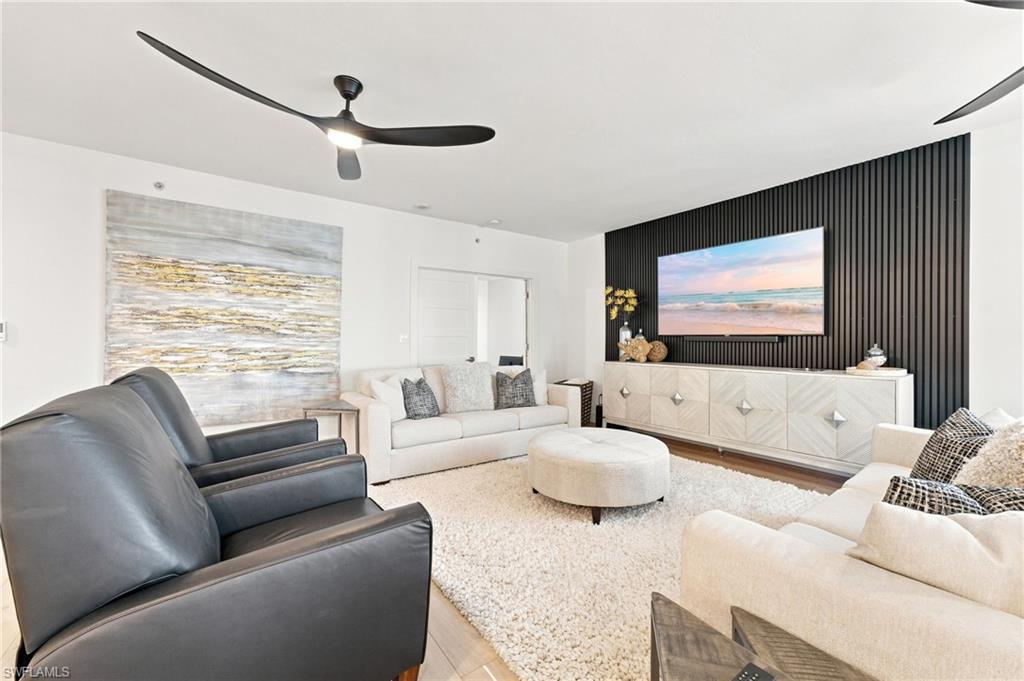 Recessed lighting, wood-finish flooring, and black accent wall with vertical paneling