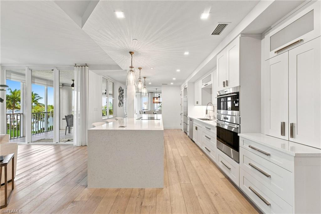 Integrated kitchen and living area featuring wood-finish flooring