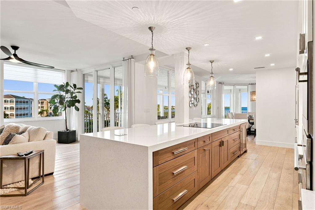 Expansive open-concept space featuring a gourmet kitchen with a large island, integrated cooktop, and built-in appliances