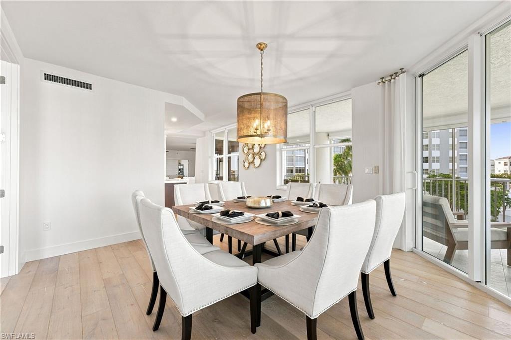 Light wood-finish flooring, a contemporary chandelier, and full-height glass sliding doors