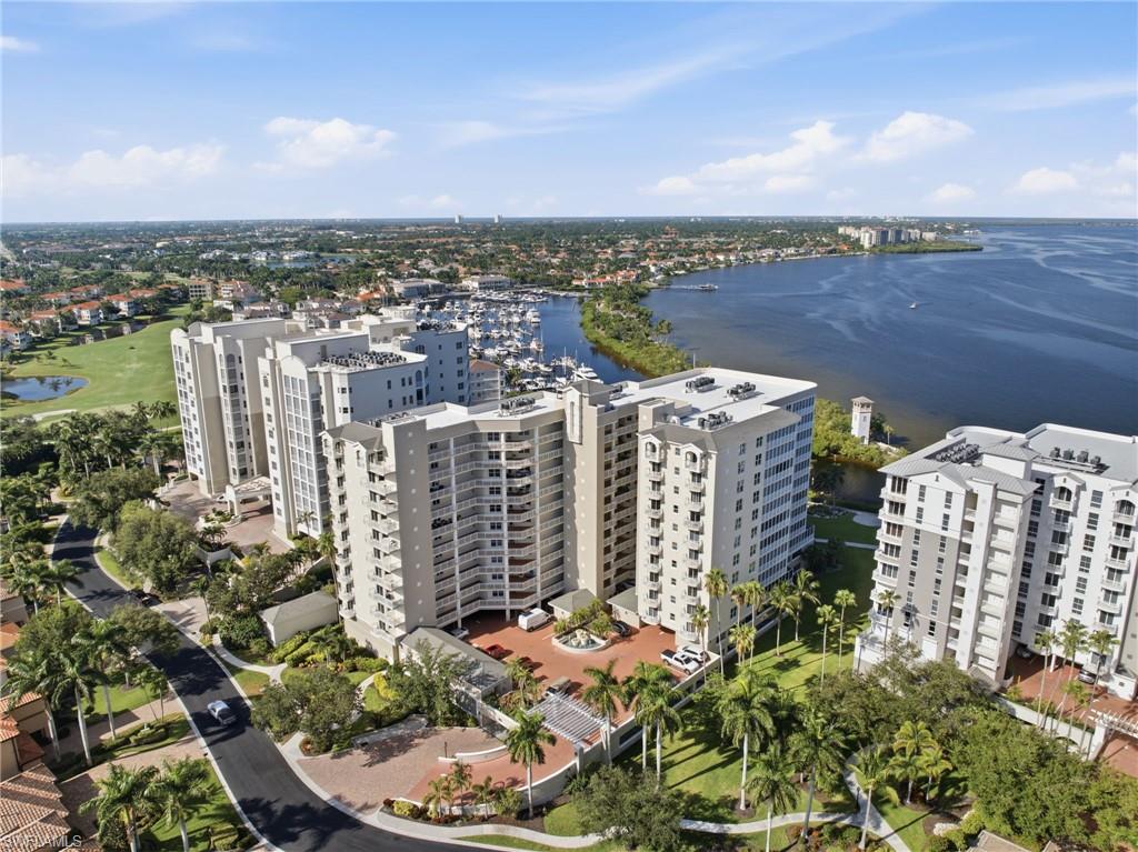 Residential high-rise buildings featuring multiple balconies, surrounded by mature palm trees and landscaped grounds