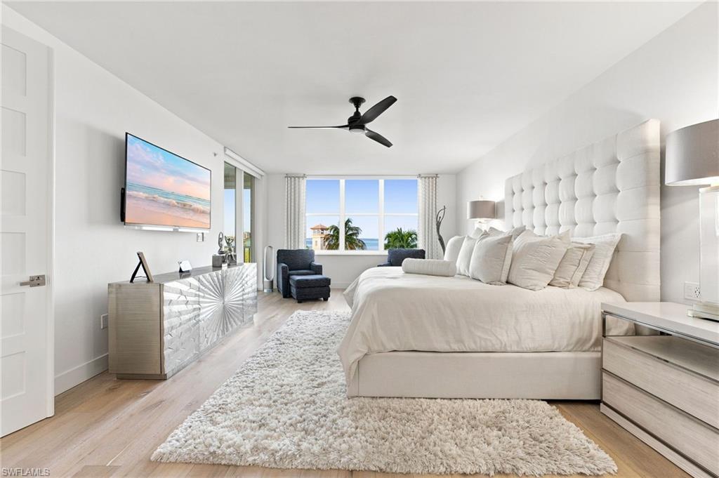 Light wood-finish flooring, a contemporary ceiling fan, and a large window offering expansive outdoor views