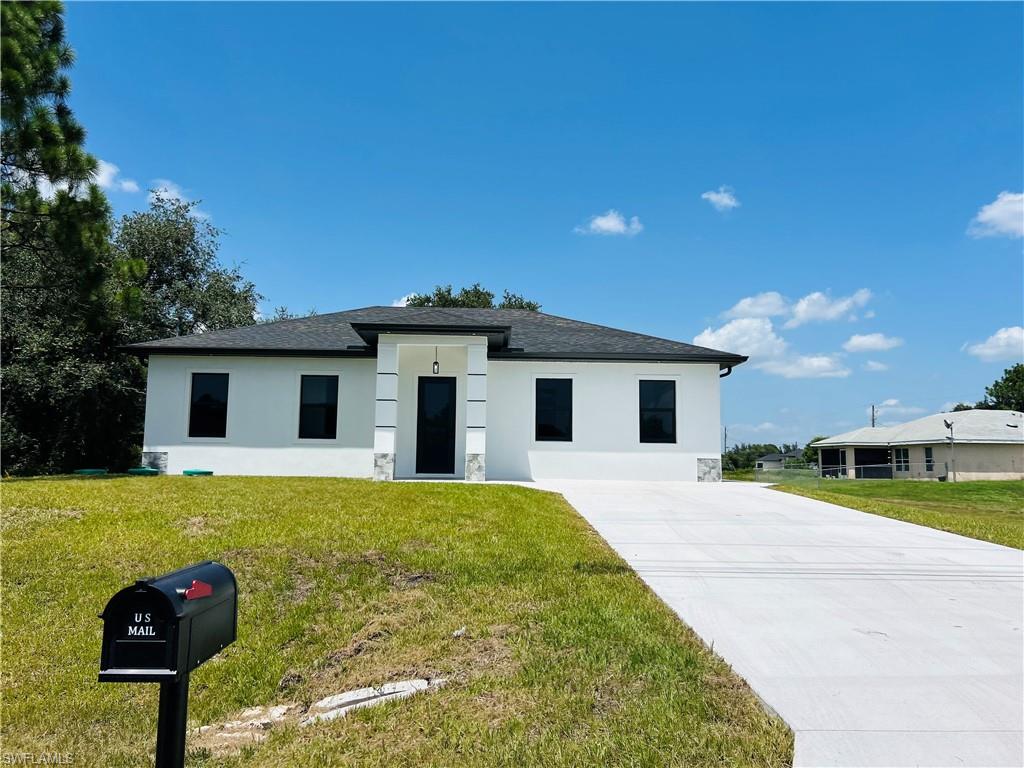 White stucco exterior with a black shingle roof
