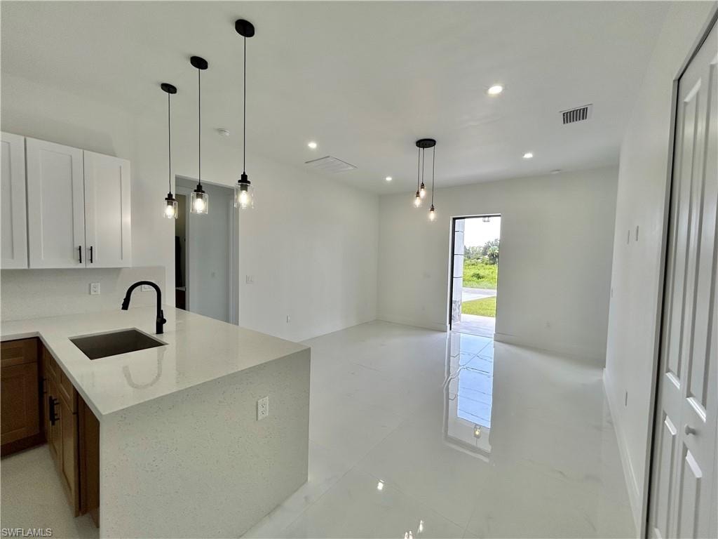 Kitchen island with light-toned countertop, black matte faucet, and built-in sink