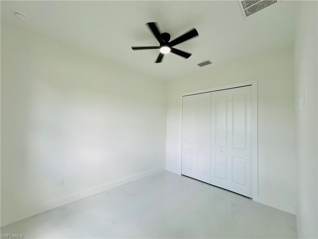 Spacious room featuring a ceiling fan with integrated lighting, bi-fold closet doors, and light-toned flooring