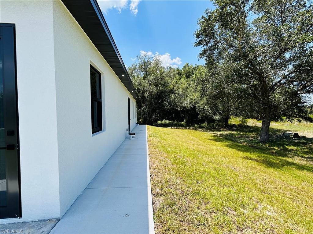 White stucco exterior with black-framed windows, black soffit, and recessed lighting