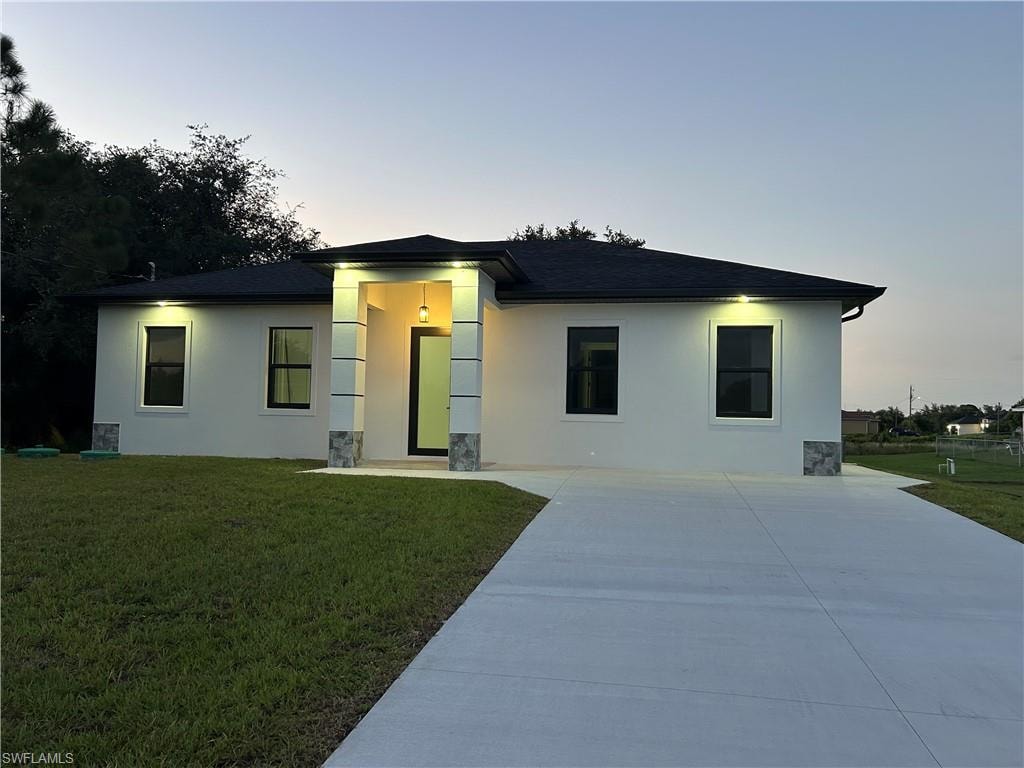 Contemporary exterior with a covered entry, dark shingle roof, and a concrete driveway
