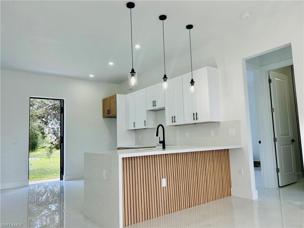Kitchen island featuring a wood-panel accent wall and quartz countertop