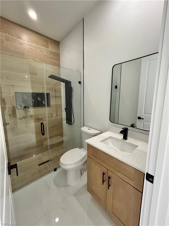 Glass-enclosed shower with wood-look tile surround and built-in niche