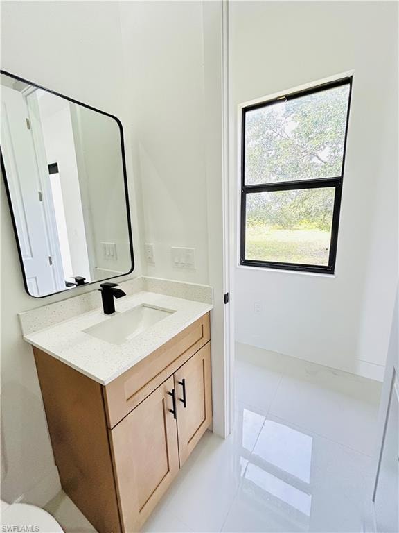 Wood-finish vanity with a light-toned countertop, integrated sink, and matte black faucet