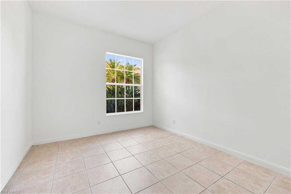 Neutral-toned ceramic tile flooring, white painted walls, and a multi-pane window