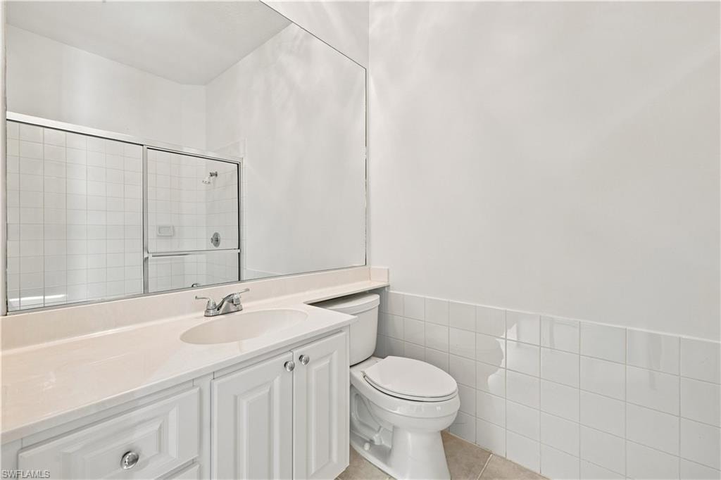 White vanity with recessed paneling and chrome hardware, a white undermount sink, and a light-colored countertop