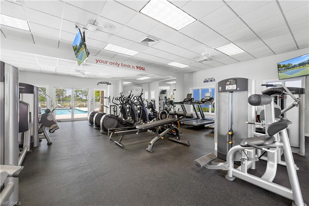 Fitness center featuring ample natural light, a variety of exercise equipment, ceiling-mounted televisions, and direct access to an outdoor pool area