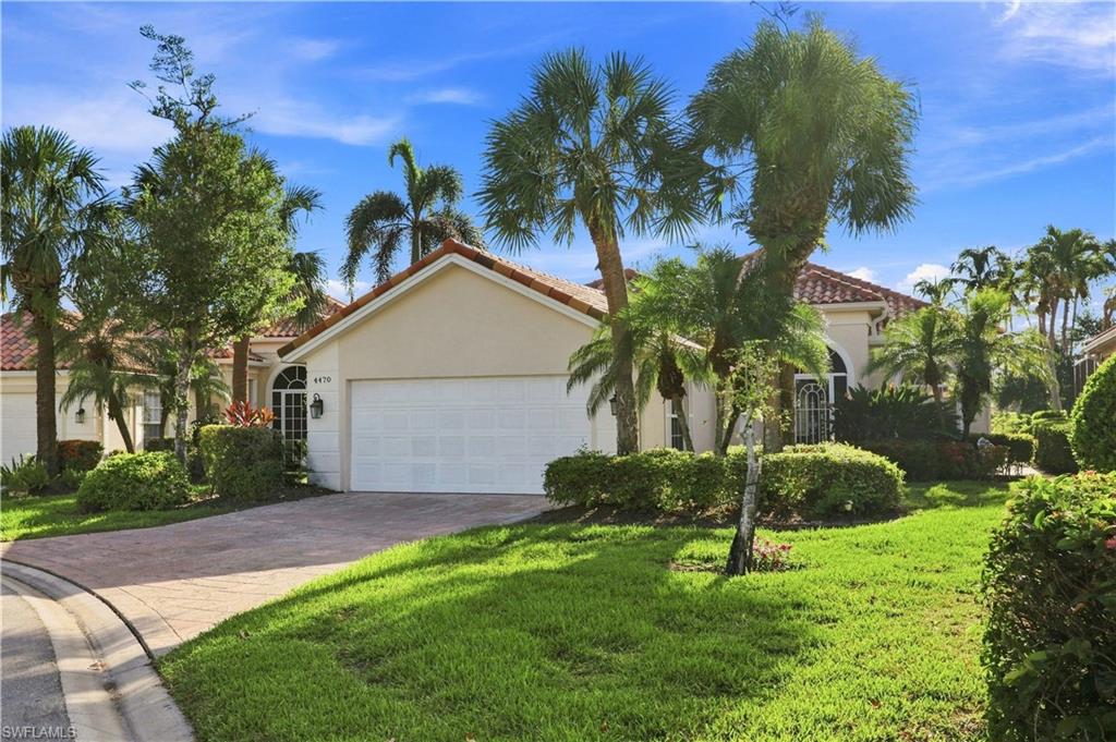 Mediterranean-style architecture with a tile roof, stucco exterior, and an arched entry with decorative ironwork
