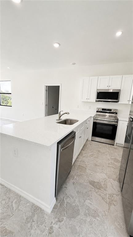 Kitchen featuring a white quartz-finish island, stainless steel appliances, white cabinetry, and recessed lighting