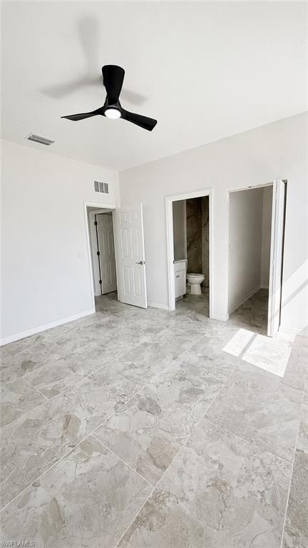 Expansive room featuring large format tile flooring, a modern black ceiling fan with integrated lighting, and a private water closet with floor-to-ceiling tile