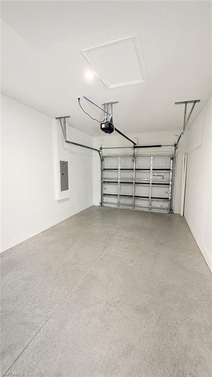 Garage with a concrete floor, white walls, and a panel garage door
