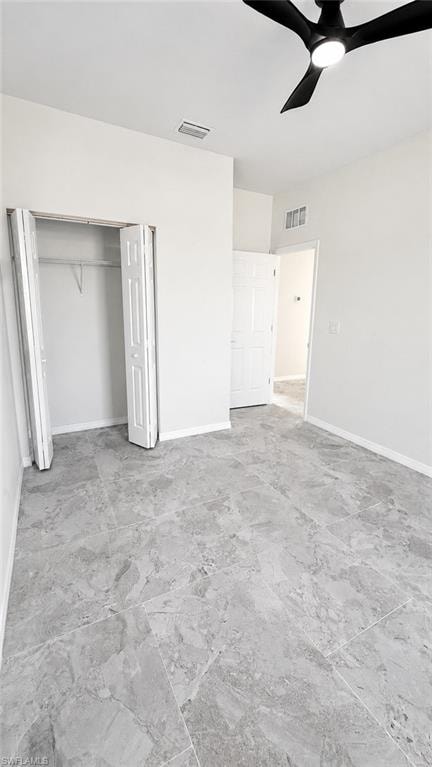 Spacious room featuring light gray tile flooring, a built-in closet with bi-fold doors, and a contemporary ceiling fan