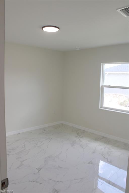White marble-look flooring, light-colored walls, white trim, and a ceiling-mounted light fixture