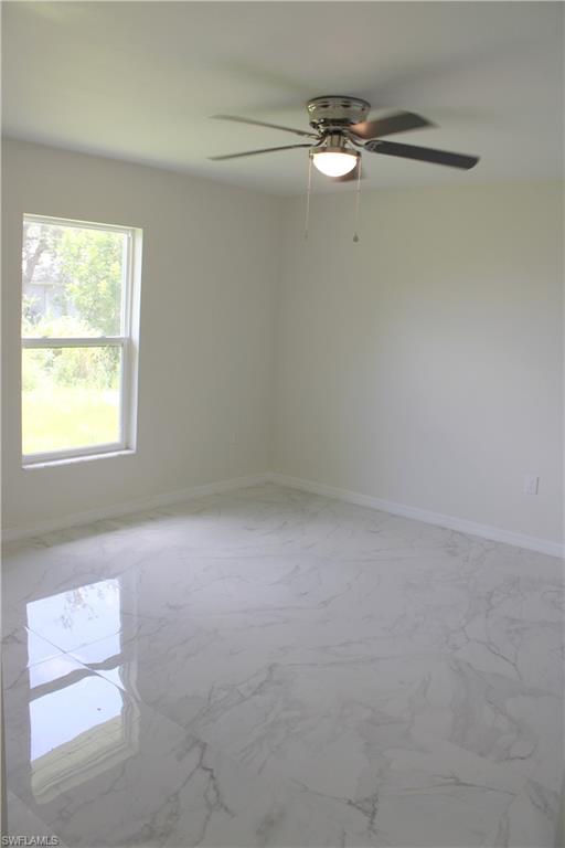 White walls, white baseboards, and a ceiling fan with integrated lighting