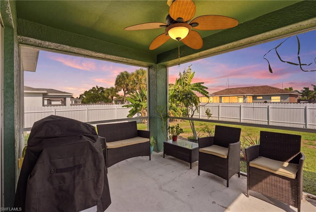 Screened patio with concrete flooring, wood-fin fan, and fenced backyard