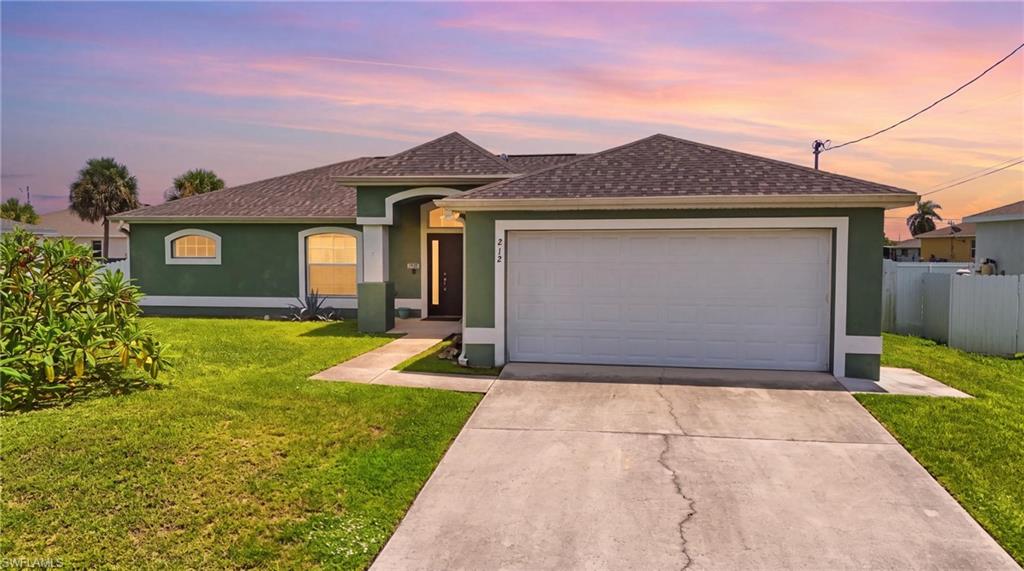 Exterior featuring a two-car garage, concrete driveway, and front walkway