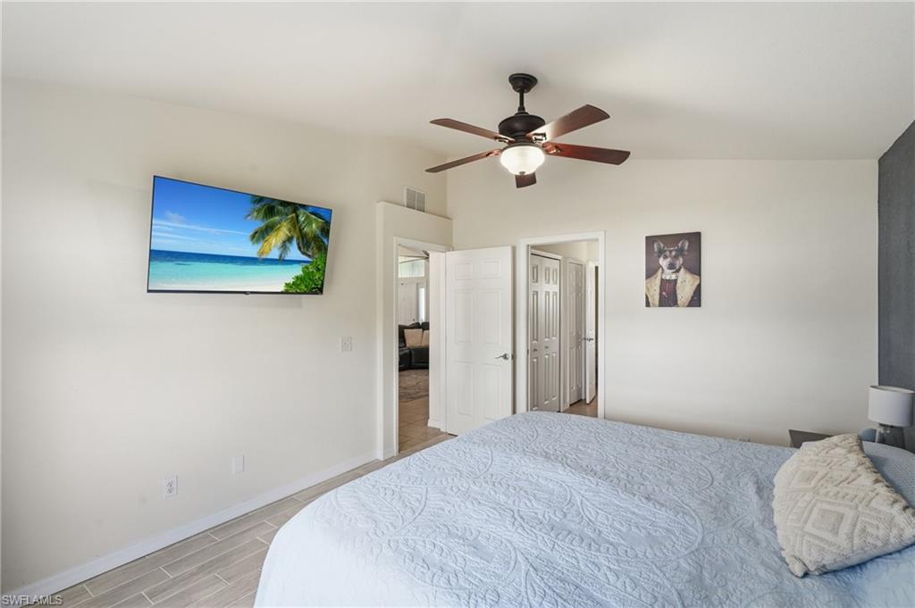 Wood-finish tile flooring with a ceiling fan featuring integrated lighting
