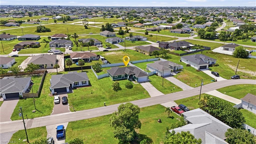 Single-story home with an attached garage, paved driveway, and established landscaping, surrounded by a residential neighborhood