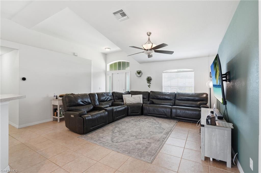 Vaulted ceilings, a ceiling fan, and tiled flooring