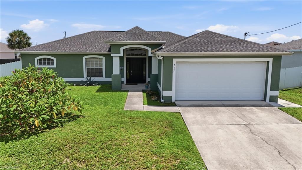 Single-story residence featuring a shingled roof, arched entryway, and an attached two-car garage