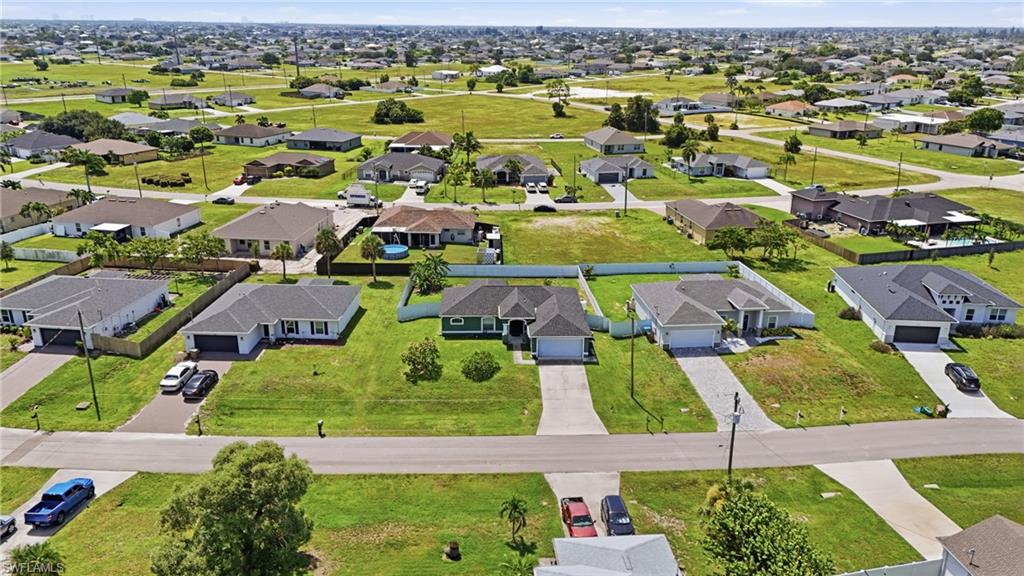 Residential neighborhood featuring various single-story homes, manicured lawns, and paved driveways