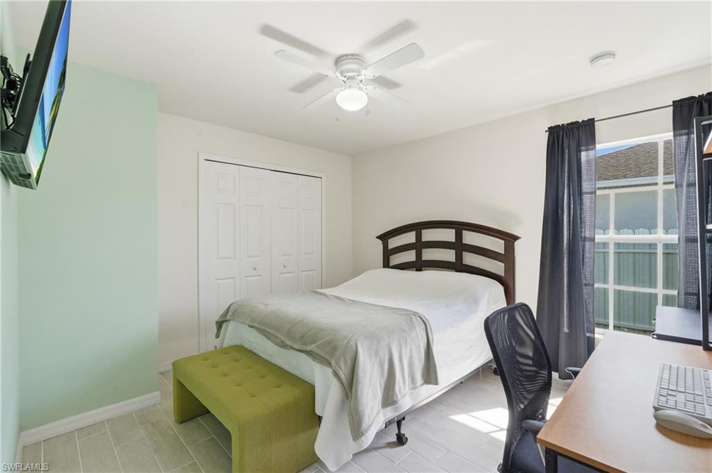 Guest Bedroom with ceiling fan, bi-fold closet doors, and tile flooring