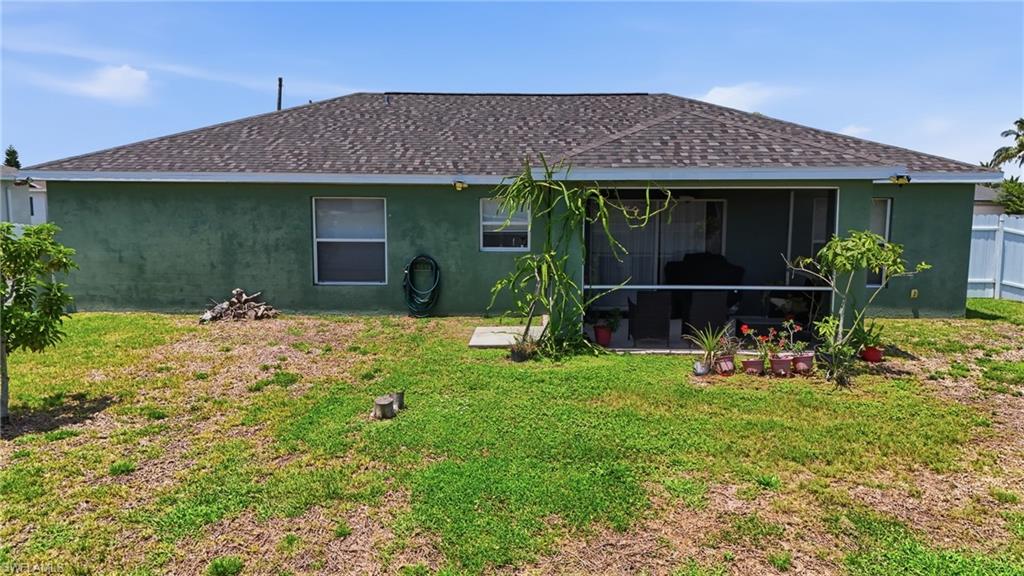 Exterior stucco finish, composite shingle roof, screened patio, and partial privacy fencing
