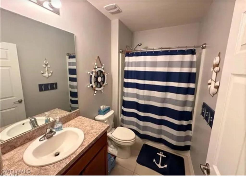 Single vanity with an integrated sink, broad wall mirror, and overhead lighting
