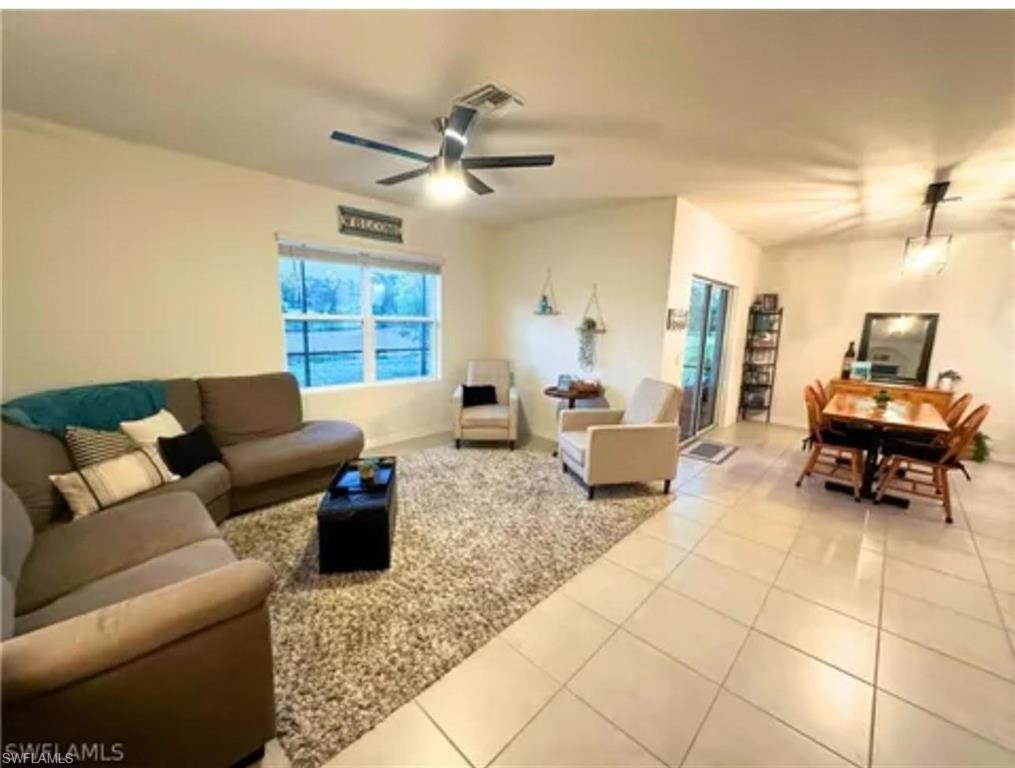 Recessed lighting, ceiling fan, and large window in living area