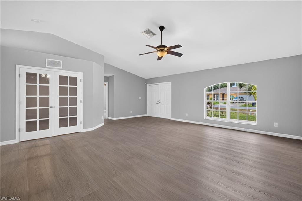 Living room facing den on left, minor bedrooms in middle, and front door on right