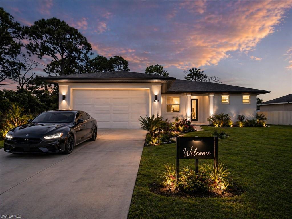 Virtually staged: Contemporary exterior showcasing a two-car garage, concrete driveway, and front lawn