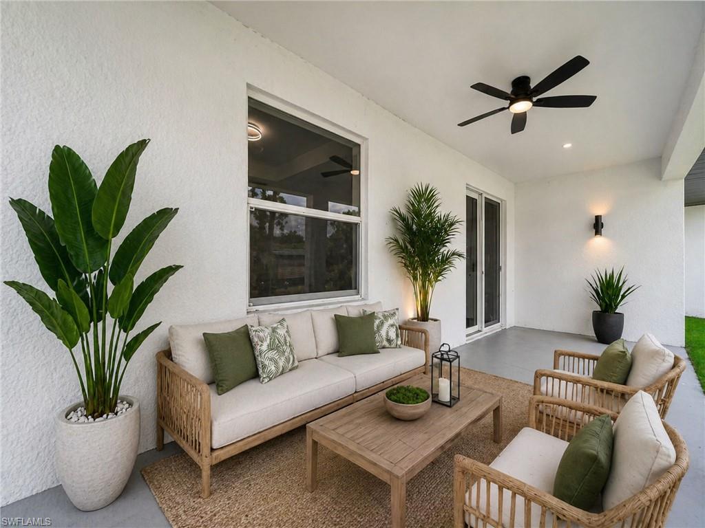 Virtually staged: Expansive covered patio featuring a ceiling fan, recessed lighting, and wall-mounted sconces