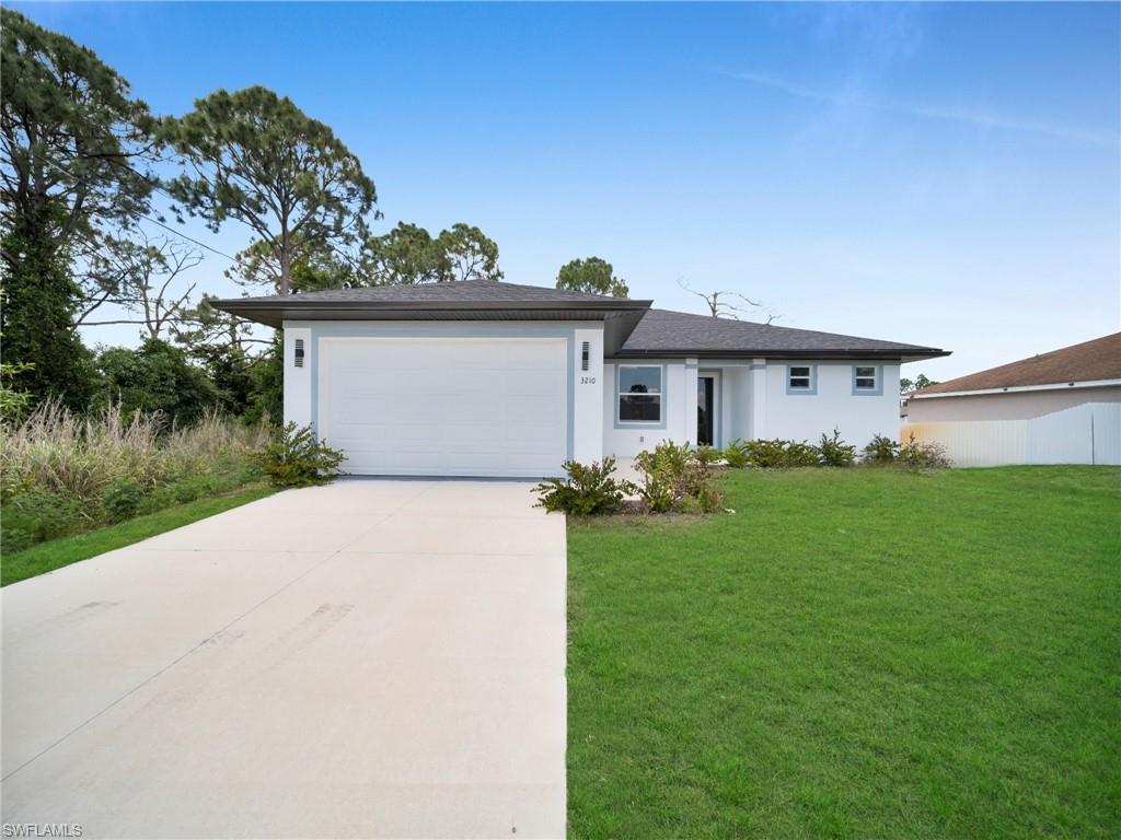 Single-story residence featuring a white facade with light blue trim accents (grass color has been enhanced)