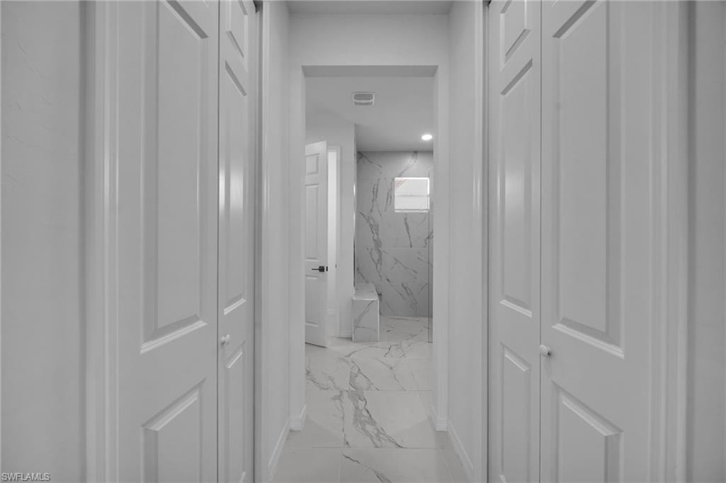 Hallway featuring white bi-fold doors and a ceiling-mounted light fixture