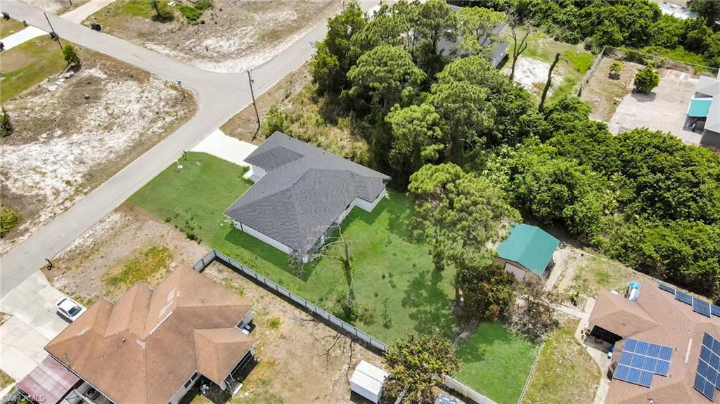 New construction residence featuring a dark shingle roof, a verdant lawn, and a light-colored exterior (grass color has been enhanced)