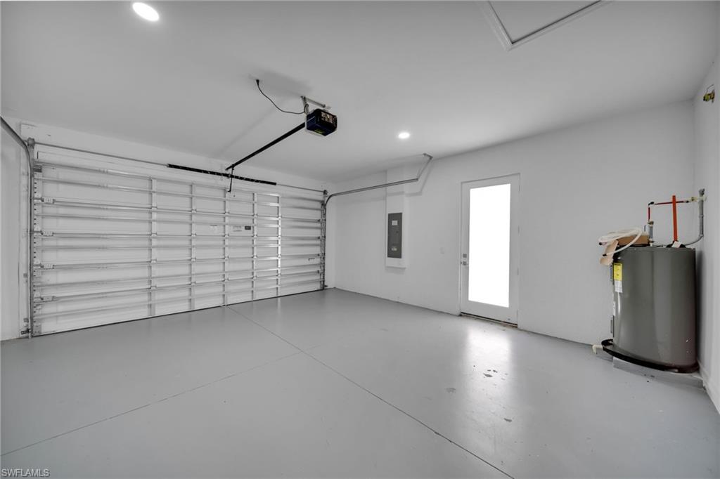 Spacious garage featuring a light gray painted floor, white walls, and a large overhead garage door