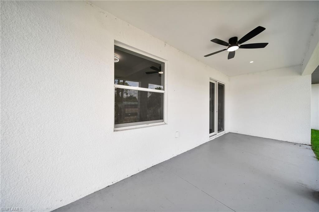 Covered patio featuring a black ceiling fan with integrated lighting, a recessed light, and sliding glass doors