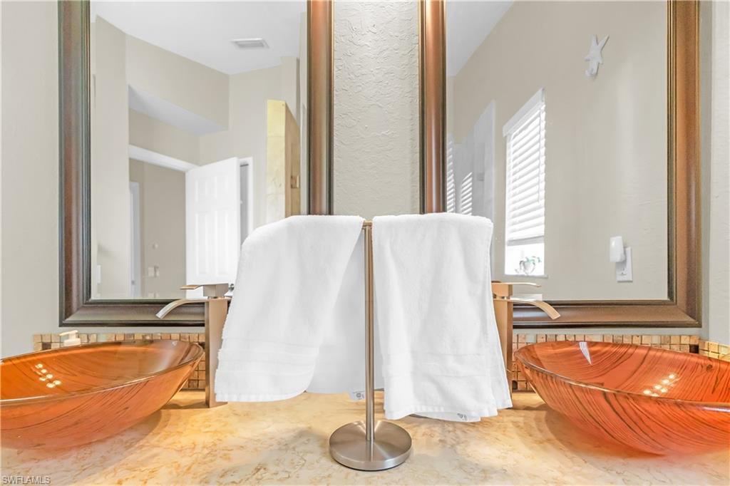 Dual vessel sinks with bronze-toned faucets, set on a stone-finish countertop