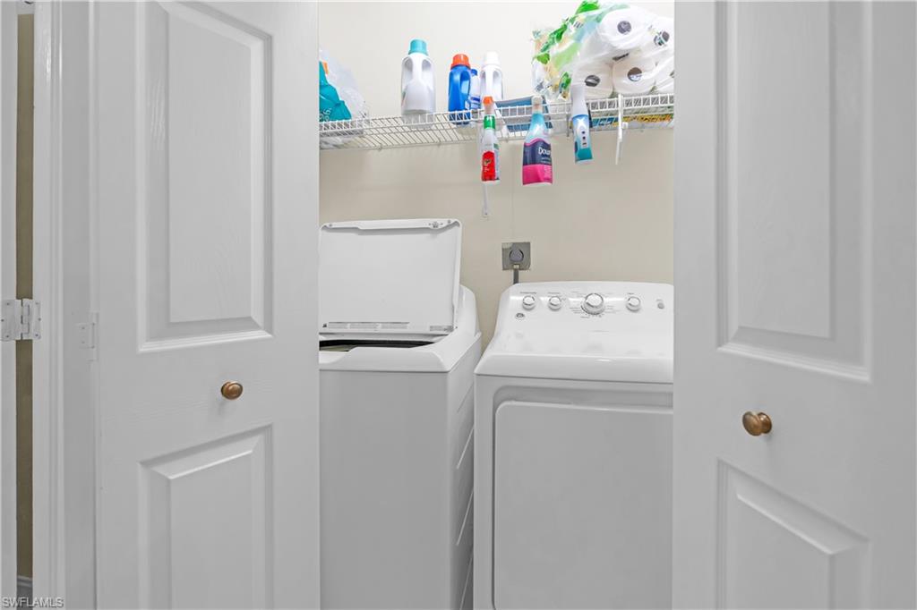 Laundry area featuring bi-fold panel doors, a top-load washing machine, and a front-load dryer